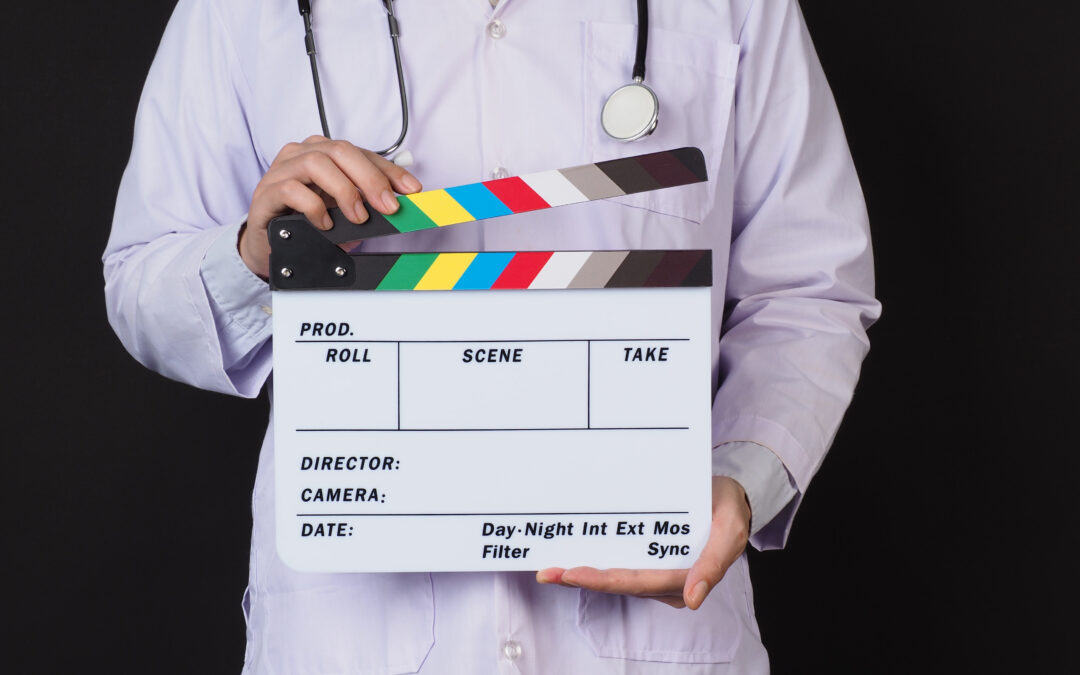 Medical experts wearing a lab coat and stethoscope holding a film production clapperboard, symbolizing their role in consulting for television and movie storytelling.