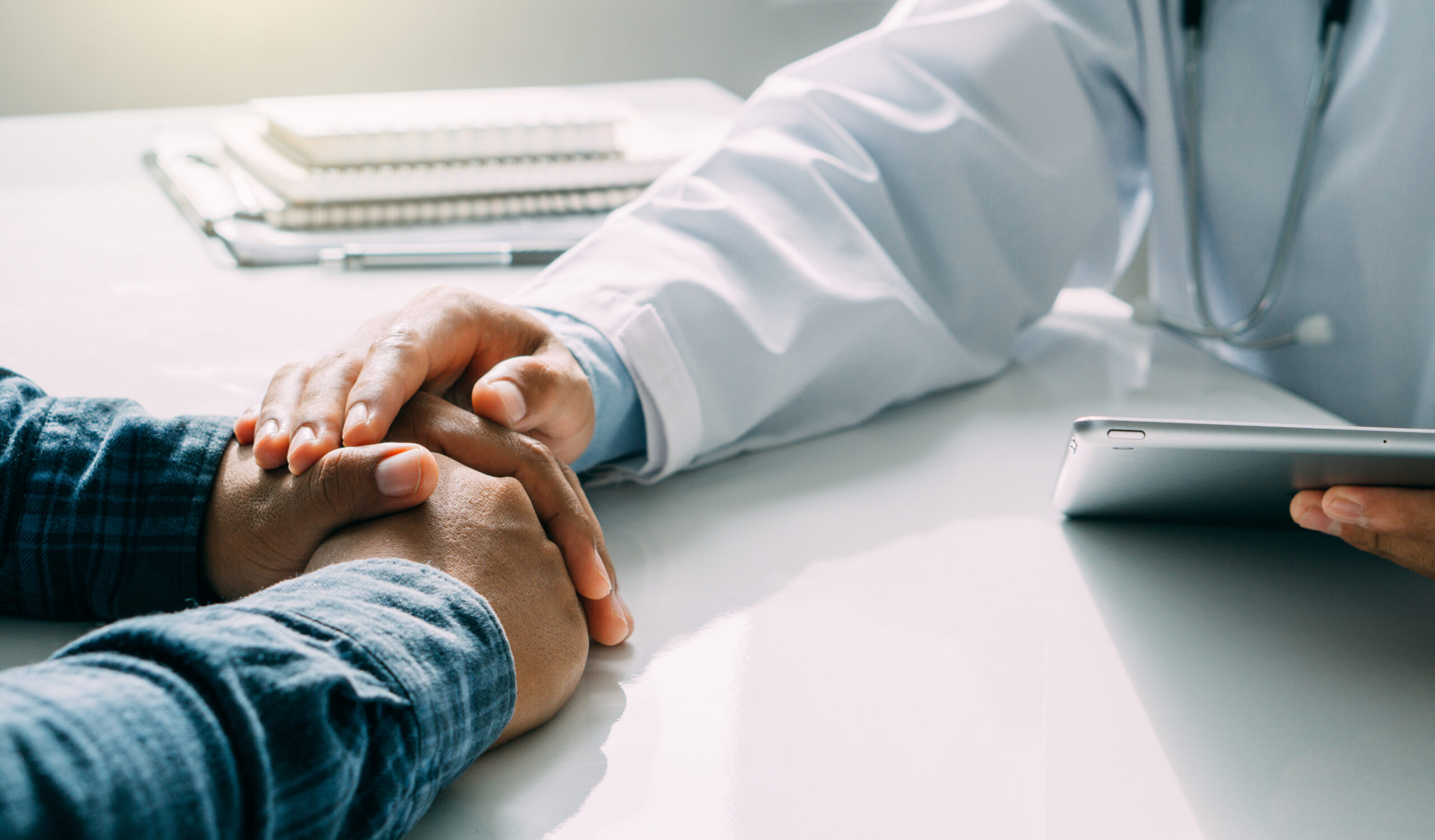 Medical experts offering compassionate support, with a doctor gently holding a patient’s hands during a consultation, symbolizing clarity and trust in wrongful death cases.